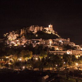 Vista de Zahara de la Sierra con el torreón del castillo en lo alto del cerro y el embalse turquesa a sus pies