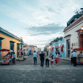 Calle colonial de Oaxaca con casas de colores y la iglesia de Santo Domingo al fondo