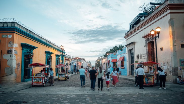 Calle colonial de Oaxaca con casas de colores y la iglesia de Santo Domingo al fondo